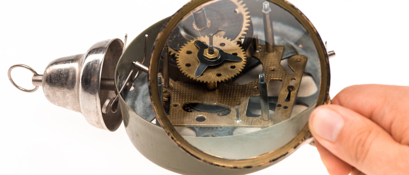 male hand with magnifier clockwork
